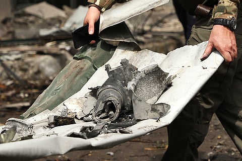 Ukrainian serviceman carries a part of the missile in Kyiv
